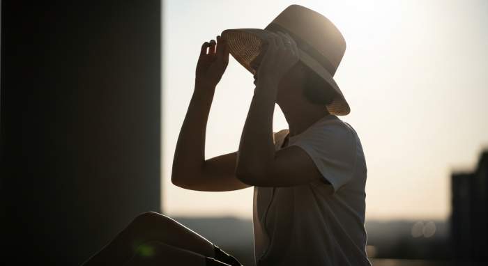 Gunesli havada golgede durarak korunan kadin yaz bakimi gorseli